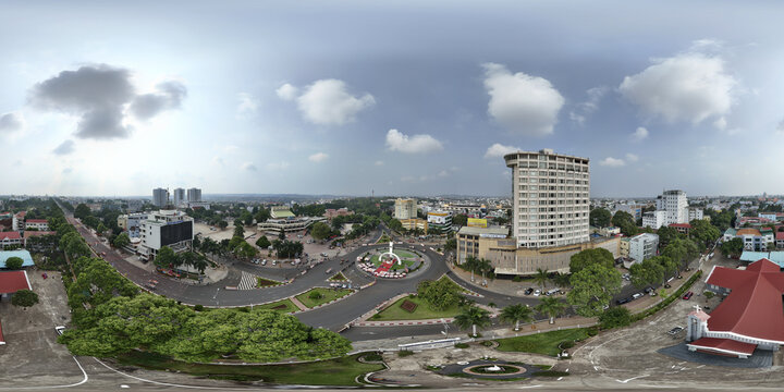 Aerial view of the roundabout and the city's buildings, with a mix of modern and traditional architecture under a cloudy sky, Buon Ma Thuot, Dak Lak, Vietnam.