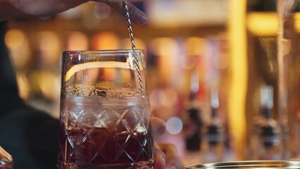 Closeup hand bartender holding jigger to measure liquor sugar into mixing glass ingredients alcohol...