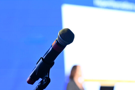 Microphone on a stand with blurred lecture background, copyspace