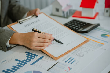 Closeup hands signing agreement document about buying home together at home, close-up hands of agent real estate giving document to elderly couple signature on contract with ownership residential.