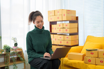 Startup SME small business entrepreneur of freelance Asian woman wearing apron using laptop and box...