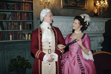 Caucasian middle aged man wearing powdered wig and ornate suit standing beside Caucasian middle...