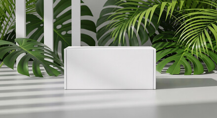 Fototapeta premium Clean white rectangular box mockup displayed in a tropical setting with lush green monstera and palm leaves and soft light
