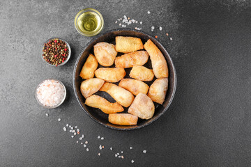 Garlic breadsticks in black bowl on dark background for appetizer, snack or pizza side concept