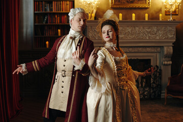 Caucasian young adult man and Caucasian young adult woman wearing Baroque period costumes...