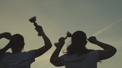 silhouette of a girl with cup in hand rejoice in victory, jump up with happiness, achieve success...
