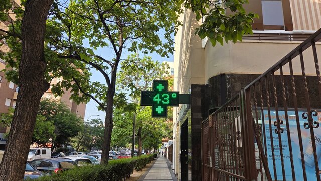 Summer heatwave in urban environment with high temperature display. Summer heat. 43 degrees Celsius on a pharmacy display in June in Zaragoza, Spain
