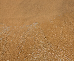 Close-up of textured golden sand with rippled patterns. Nature backgoroung image.