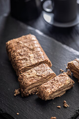 Halva with cocoa. Sweet oriental dessert on black table.