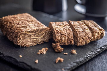 Halva with cocoa. Sweet oriental dessert on black table.