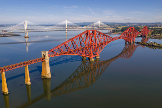 Aerial image featuring the Forth bridge with the Forth Road Bridge and Queensferry crossing Bridge on the background. Edinburgh - Scotland. 