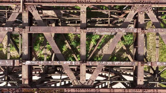 Aerial View of Rusted Steel Bridge Structure with Overgrown Vegetation