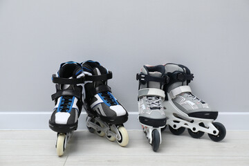 Pairs of roller skates on floor near white wall