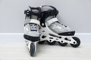 Pair of roller skates on floor near white wall