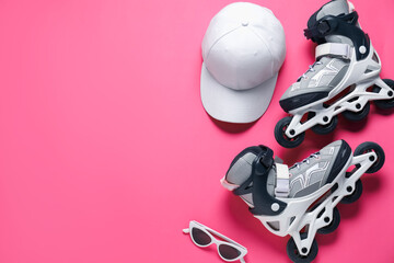 Flat lay composition with roller skates on pink background. Space for text