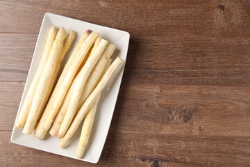 Raw white asparagus spears on wooden table, top view. Space for text