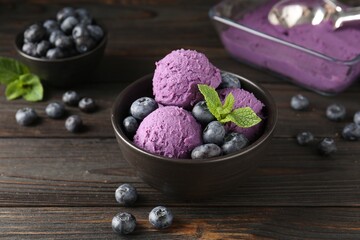 Tasty sorbet with blueberries and mint in bowl on wooden table, closeup