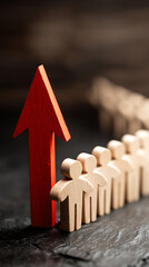Red arrow leading wooden figures forward on dark textured surface leadership progress