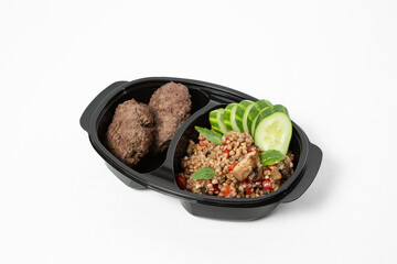 Steamed beef cutlets with buckwheat, sautéed mushrooms, and fresh cucumber slices, served on a plate against a white background