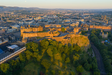 Aerial image of a golden sunrise over a hilltop of Edinburgh Castle in Scotland, UK. 
