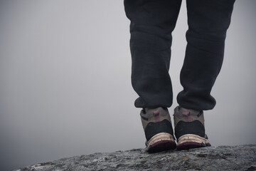 Woman walking in the mountains while it is very foggy.