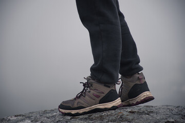 Woman walking in the mountains while it is very foggy.