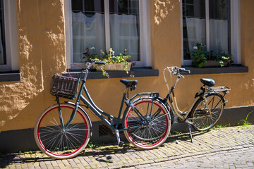 Vintage bicycles parked along the Assenstraat in Deventer past stately old houses. High quality photo