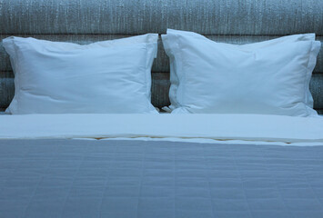 bed with several rectangular pillows and a blanket