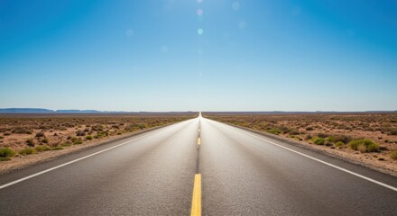 Naklejka premium Open highway stretching through desert landscape under clear blue sky 