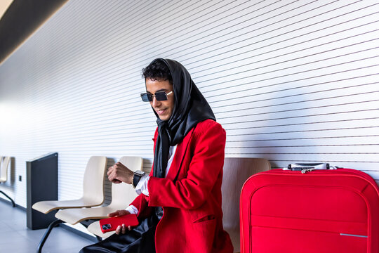 Latin businessman waiting at airport checking time on smartwatch