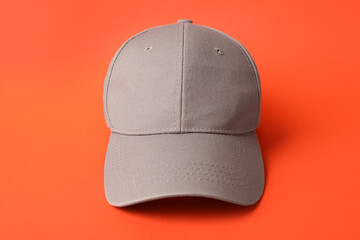 Beige baseball hat on orange background, closeup. Mockup for design