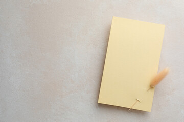 Wedding invitation card with spike on color textured table, top view. Space for text