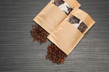 Zipper stand-up pouches and coffee beans on black textured table, flat lay. Mockup for design