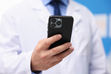 Doctor with smartphone in clinic, closeup. Online medical consultation