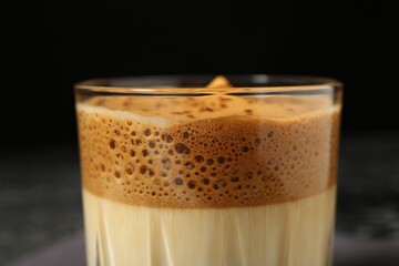 Delicious dalgona coffee in glass on blurred background, closeup