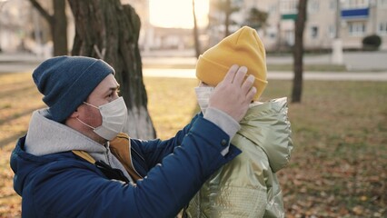 man child put medical face masks park. protection against coronavirus pandemic omicron delta...