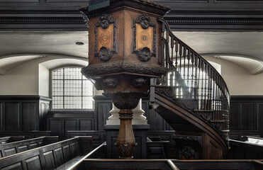Ornately carved wooden pulpit with an attached staircase, which is located in St...