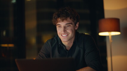 Creative freelancer developing project at laptop sitting night workplace closeup