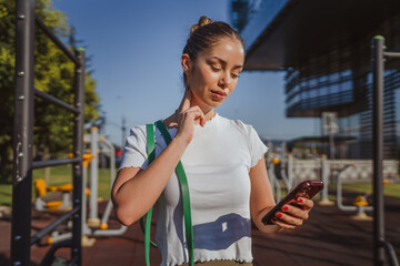woman take a brake and use mobile phone in the outdoor gym