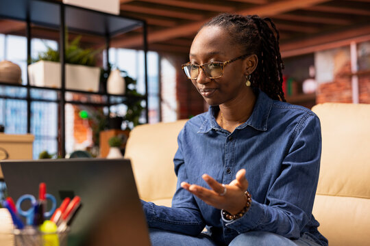 Confident woman participate at a webinar course from home office, meeting with a professor via video call connection. Woman studying hard for her master degree remotely, teleconference.