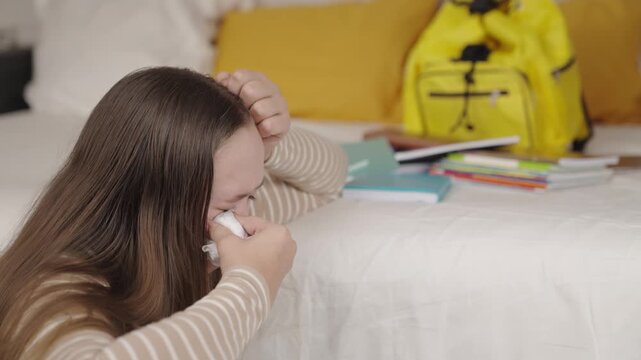 teenage girl crying wiping tears from wet eyes on her face, school difficulties upset child, resentment relationships with peers, psycho kid whims, sadness and loneliness with textbooks and backpack.
