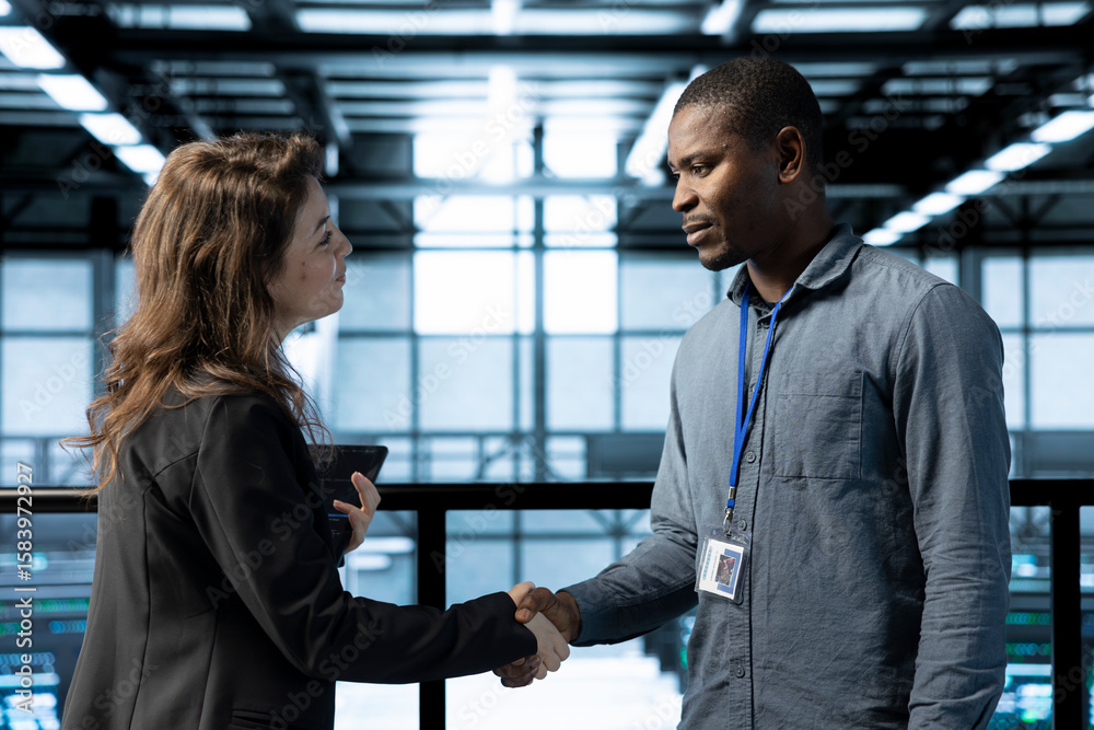 Poster manager meeting with computer scientist in data center, coming to inspect servers. supervisor doing 