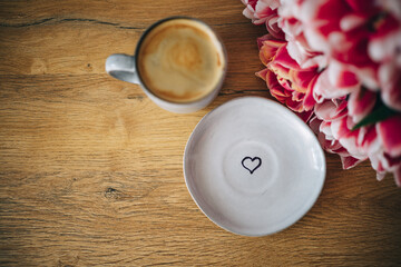 Spring tulips and cup of coffee on wooden table