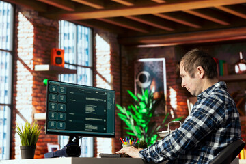 Man seated at desk speaking with AI LLM chatbot software in modern home office. Person...