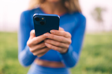 Fitness woman using mobilephone while exercising. Smiling woman doing stretching workout 