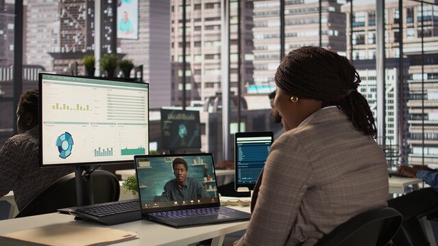 Black director discuss on a video call with business consultant for a new strategy, uses remote communication on online conference to establish objectives. Connection with specialist. Camera B.