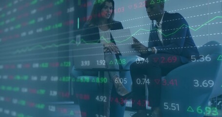 Woman opening laptop and scrolling financial data while man tapping phone reviewing chart overlays - Powered by Adobe