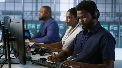 Data center admin typing on keyboard, maintaining company network infrastructure by configuring...
