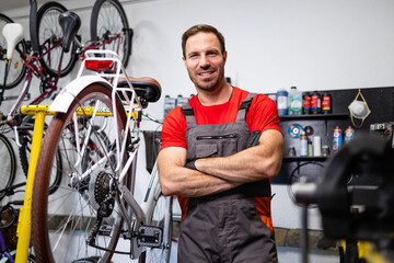 Portrait of caucasian bicycle mechanic holding arms crossed.