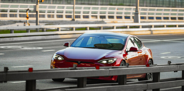 Electric luxury on the move &mdash; a red Tesla Model S driving on a highway, symbolizing the future of transportation, speed, and clean energy